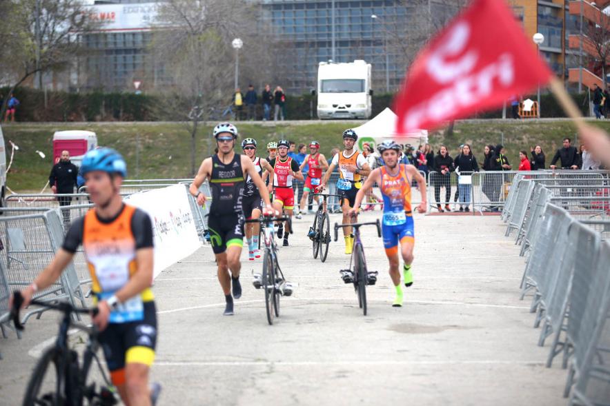 Campeonato de España de Duatlón -  Plano central de los  numerosos participantes llevando la bicicleta de la mano.
