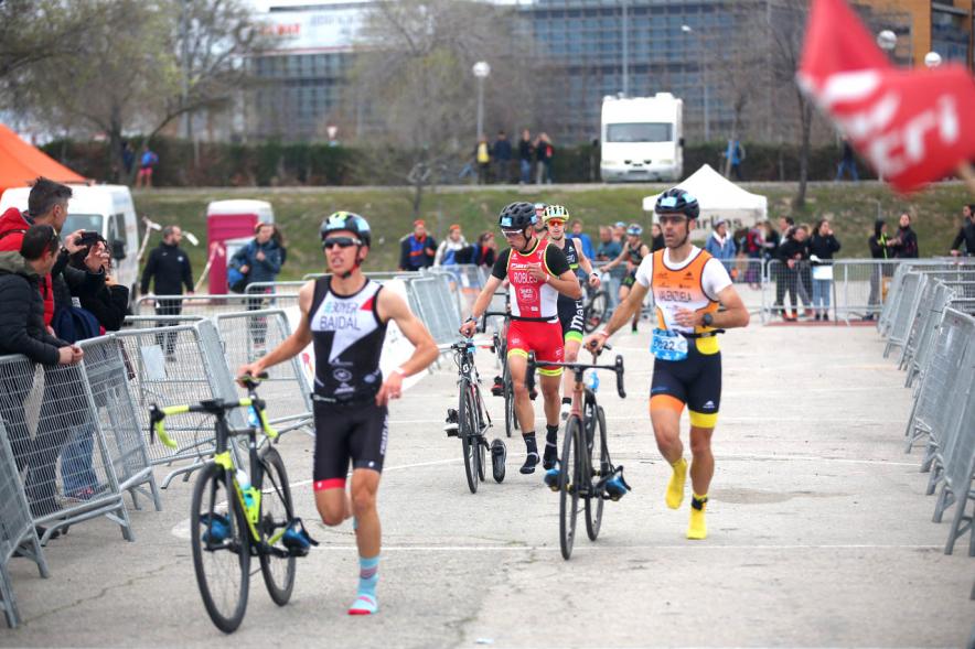 Campeonato de España de Duatlón -   Plano central de los  participantes llevando la bicicleta de la mano.