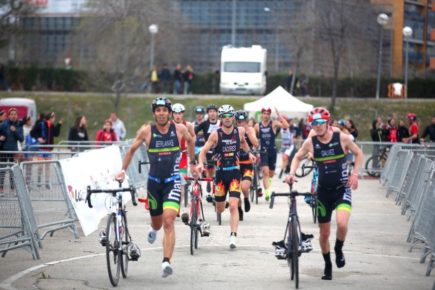 Campeonato de España de Duatlón - Plano central de los  numerosos participantes llevando la bicicleta de la mano.