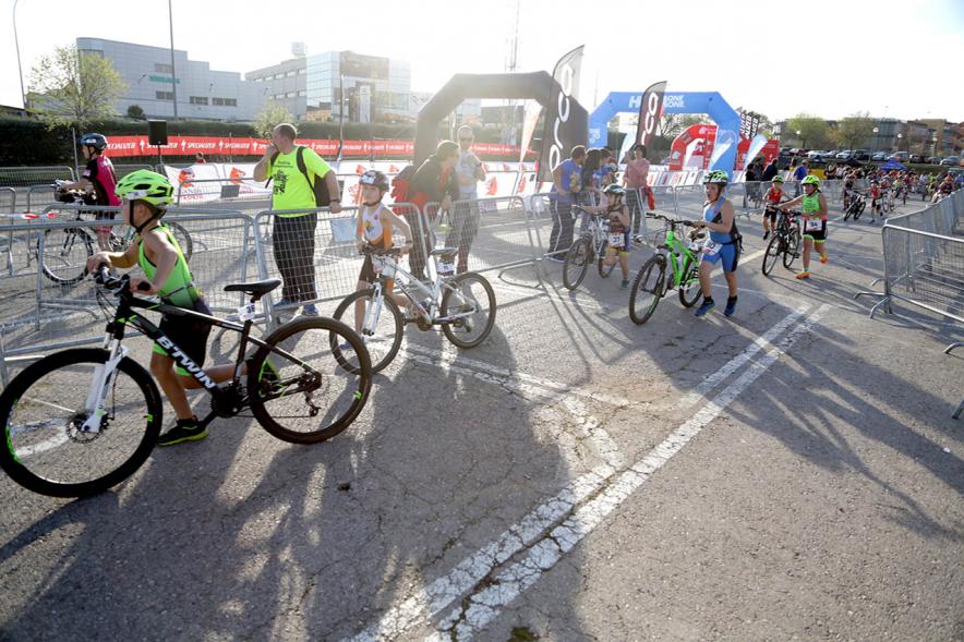 Duatlón Escolar Villa de Alcobendas - Imagen de un grupo numeroso de deportistas empujando las bicicletas.