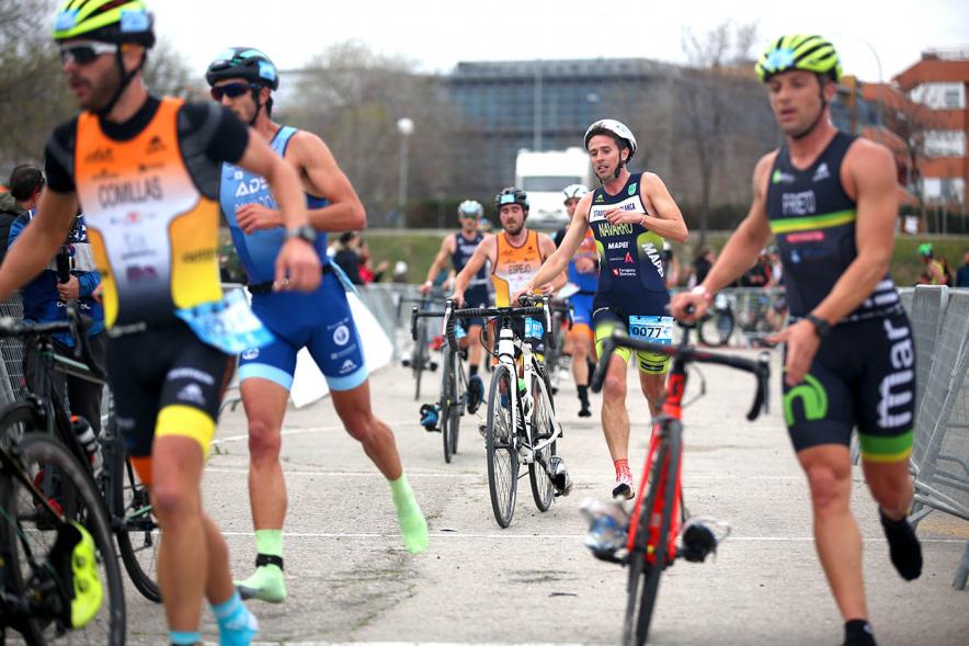 Campeonato de España de Duatlón -   Imagen de tres participantes a pie llevando la bicicleta.
