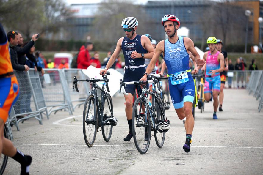 Campeonato de España de Duatlón -  Plano central de los  numerosos participantes llevando la bicicleta de la mano.