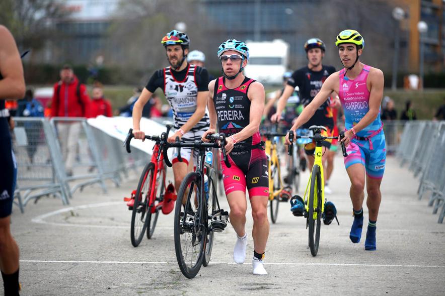 Campeonato de España de Duatlón -  Imagen de tres participantes a pie llevando la bicicleta.