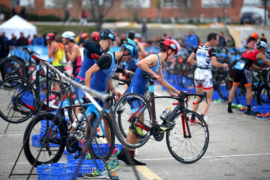 Campeonato de España de Duatlón - Primer plano de los participantes recogiendo las bicicletas.