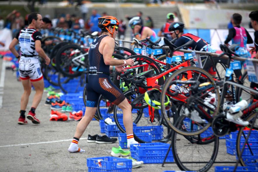 Campeonato de España de Duatlón - Primer plano de varios participantes soltando rápidamente las bicicletas.