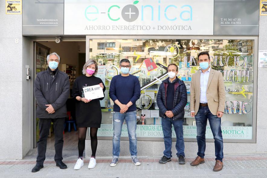 Delegación municipal posando ante un escaparate