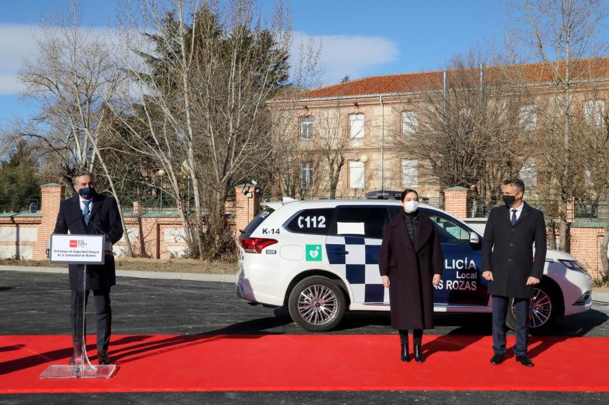 Presentación del ESICAM179 y Entrega de Medallas al Mérito Policial - Plano abierto del Consejero de la Presidencia Enrique López junto a la Presidenta de la comunidad de Madrid, un colaborador y un coche patrulla.
