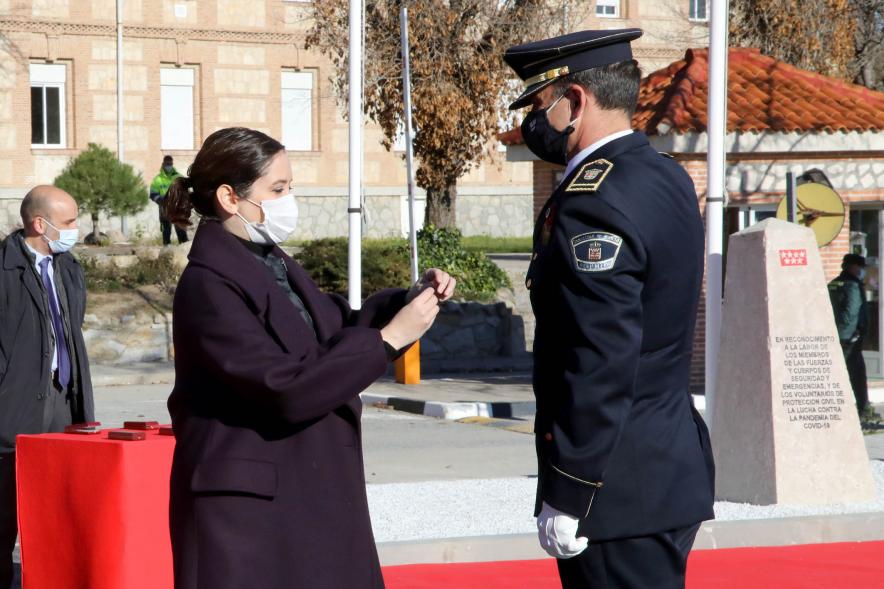 Presentación del ESICAM179 y Entrega de Medallas al Mérito Policial -Imagen de la Presidenta de la Comunidad de Madrid condecorando a un Policía, todos con mascarillas.
