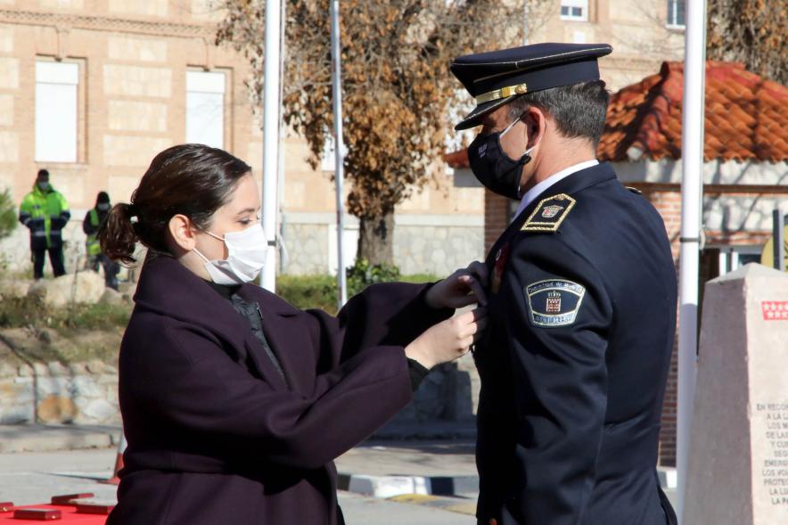 Presentación del ESICAM179 y Entrega de Medallas al Mérito Policial - Imagen de la Presidenta de la Comunidad de Madrid condecorando a un Policía, todos con mascarillas.