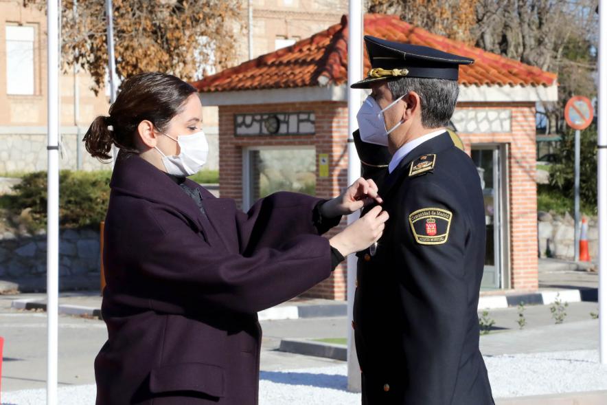 Presentación del ESICAM179 y Entrega de Medallas al Mérito Policial - Imagen de la Presidenta de la Comunidad de Madrid condecorando a un Policía, todos con mascarillas.