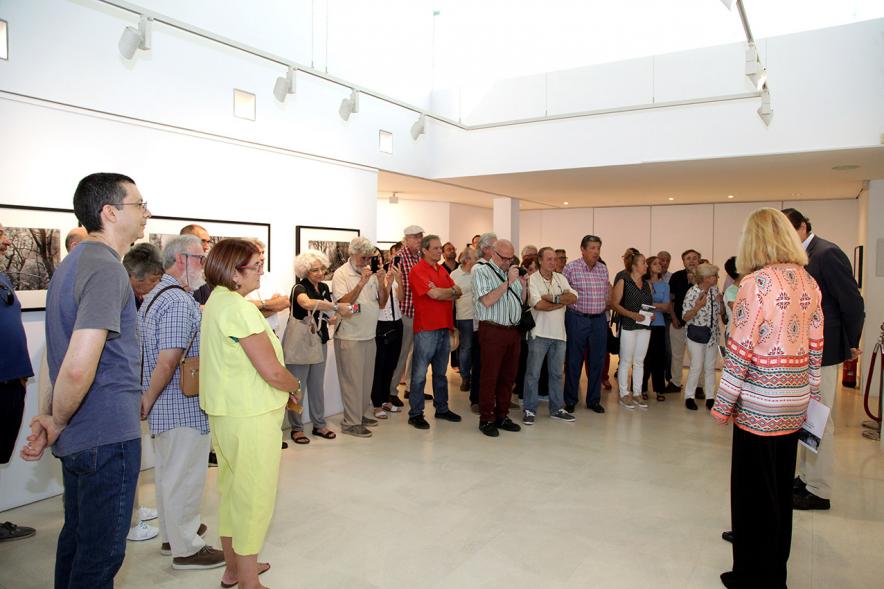 Inauguración Exposición Memorandum Natura - Imagen de la autora de las fotografías dando  explicaciones a los asistentes sobre su obra.