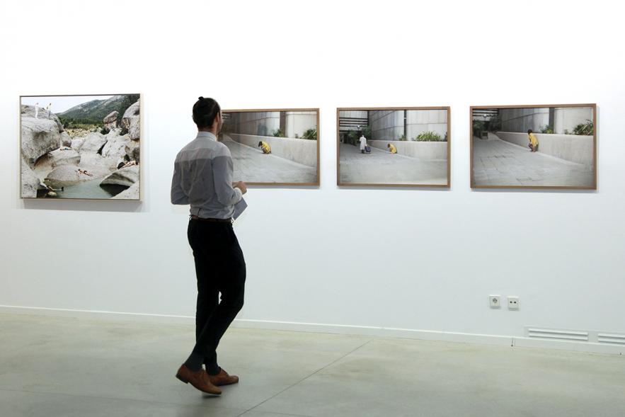 Inauguración de la Exposición "En lo Salvaje" en el Cantro de Arte - Persona mirando imágenes de la exposición.