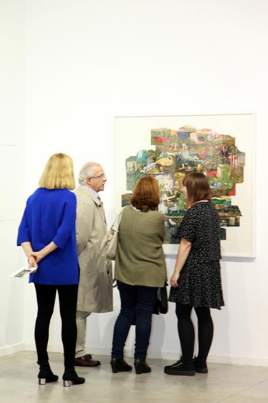 Inauguración de la Exposición "En lo Salvaje" en el Cantro de Arte - Personas mirando imágenes de la exposición.