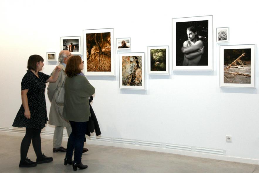 Inauguración de la Exposición "En lo Salvaje" en el Cantro de Arte - Personas mirando imágenes de la exposición.