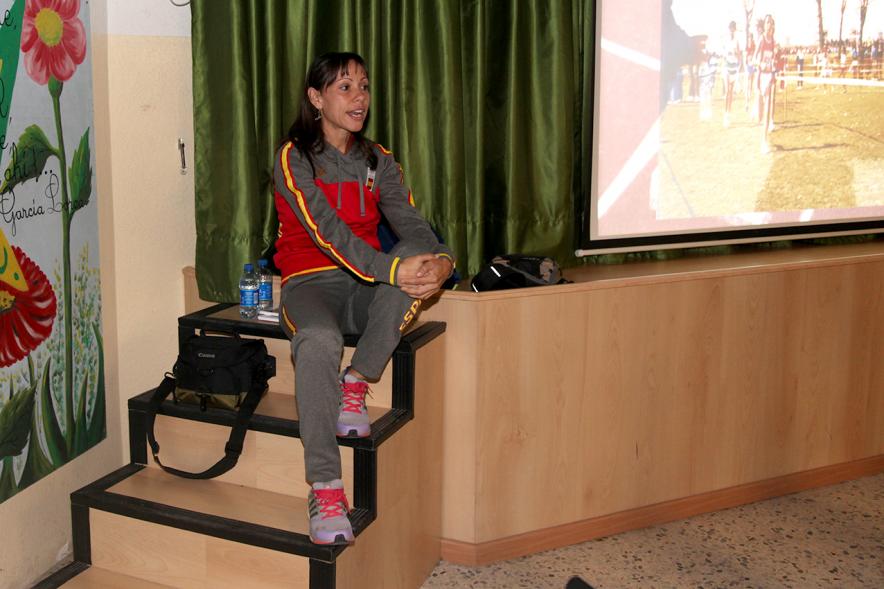 Azucena Díaz sentada en una escalera cuenta su experiencia a los alumnos