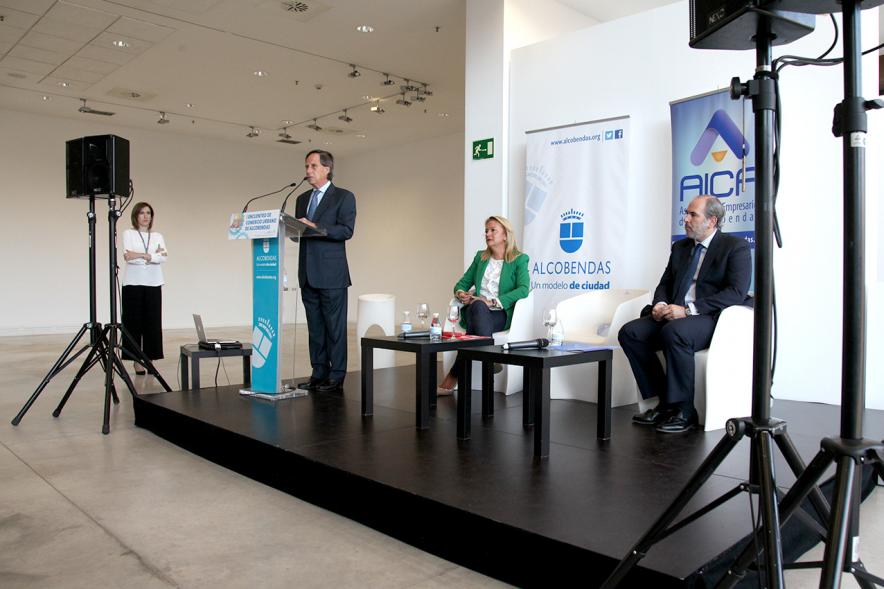 Ier Encuentro de Comercio Urbano de Alcobendas -  Imagen del escenario, donde el alcalde García de Vinuesa esta dirigiéndose a los asistentes y demás oradores.