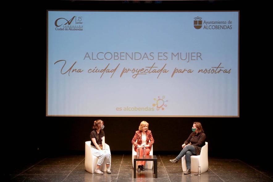 Semana contra la Violencia de Género - Encuentro con Oihane Ruíz - Primer plano del escenario con Ofelia Culebradas de la Concejalía de la Mujer y dos ponentes.