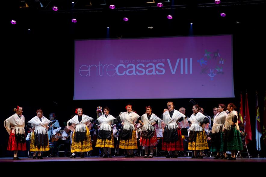 VIIIº Entrecasas - Festival de las Casas Regionales - Posado del grupo folclórico femenino junto al cartel del festival.