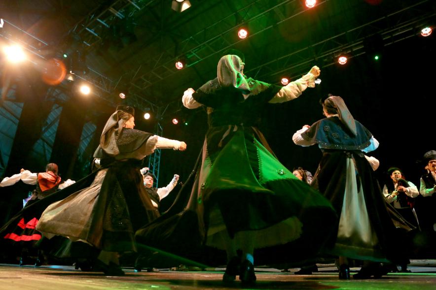 VIIIº Entrecasas - Festival de las Casas Regionales -  Primer plano a contraluz de las danzantes  del grupo folclórico  gallego. 