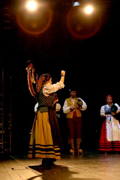 VIIIº Entrecasas - Festival de las Casas Regionales - Primer plano de una muñeira, con los músicos en el escenario.