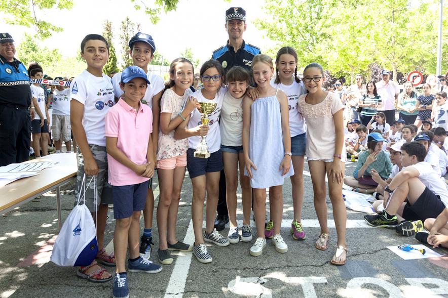 Entrega Premios XXIIº Concurso Escolar de Dibujo y Eslogan sobre Educaión y Seguridad Vial - Imagen de los niños premiados junto con una fuerza del orden asistentes al acto.
