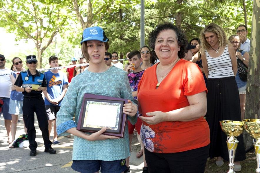 Entrega Premios XXIIº Concurso Escolar de Dibujo y Eslogan sobre Educaión y Seguridad Vial - Imagen de una niña premiada junto con una autoridad asistente al acto.
