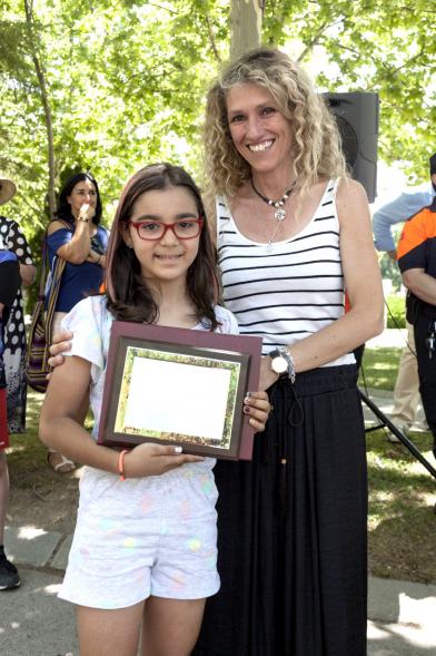 Entrega Premios XXIIº Concurso Escolar de Dibujo y Eslogan sobre Educaión y Seguridad Vial - Imagen de una niña premiada junto con una autoridad asistente al acto.