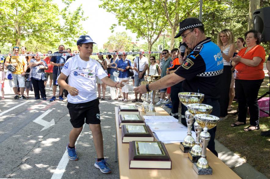 Entrega Premios XXIIº Concurso Escolar de Dibujo y Eslogan sobre Educaión y Seguridad Vial - Imagen de un niño recogiendo su diploma de manos de un miembro de las fuerzas públicas.