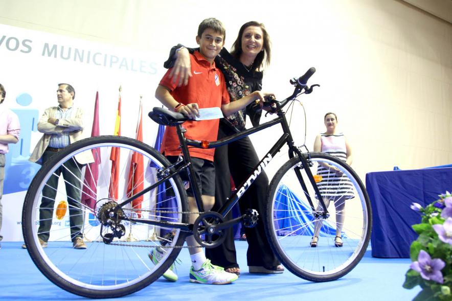Entrega de Trofeos de Competiciones Locales 2016-17 - Imagen de un niño recibiendo su premio que es una bicicleta de montaña.