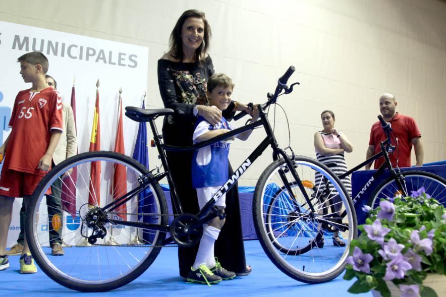 Entrega de Trofeos de Competiciones Locales 2016-17 - Imagen de un niño recibiendo su premio que es una bicicleta de montaña.