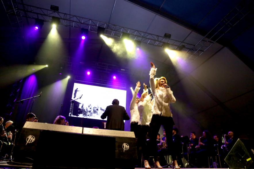 Artistas en el escenario iluminados por los focos