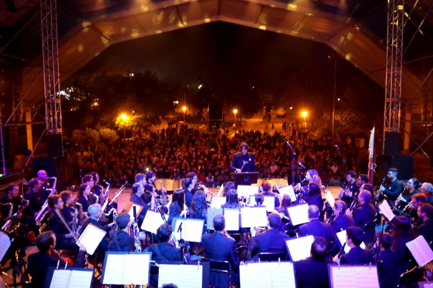 Miembros de la orquesta con público al fondo