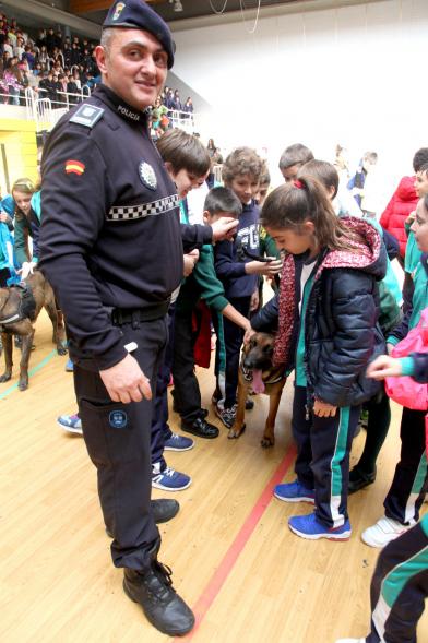 Iª Exhibición de la Unidad Canina de la Policía Local - Imagen de un policía y su perro policía junto a unos niños.