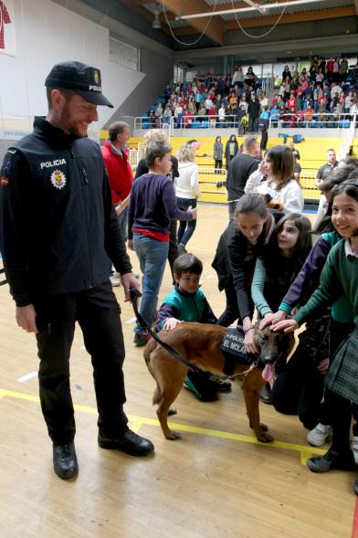 Iª Exhibición de la Unidad Canina de la Policía Local - Imagen de un policía y su perro policía junto a unos niños.