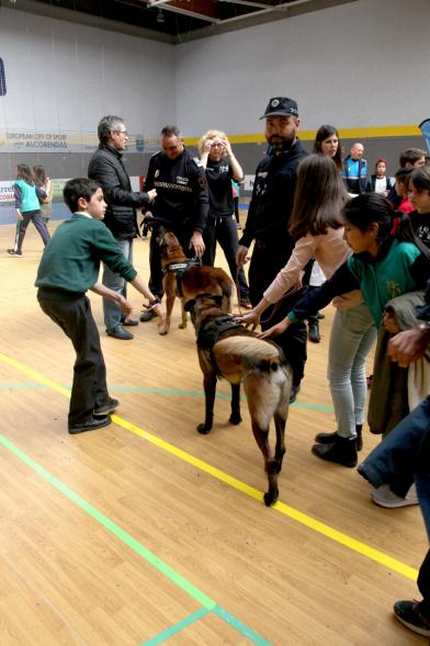 Iª Exhibición de la Unidad Canina de la Policía Local - Imagen de un policía y su perro policía junto a unos niños.