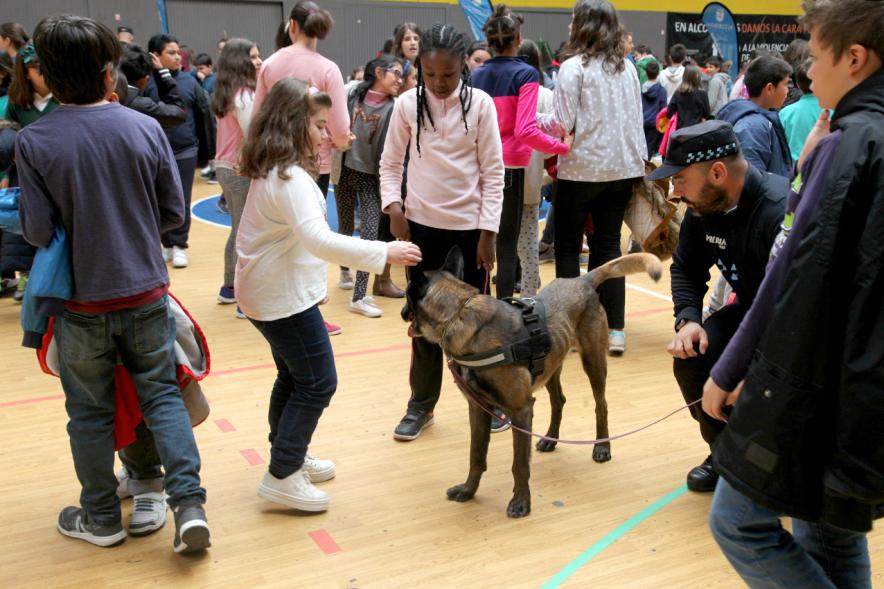 Iª Exhibición de la Unidad Canina de la Policía Local - Imagen de un policía y su perro policía junto a unos niños.
