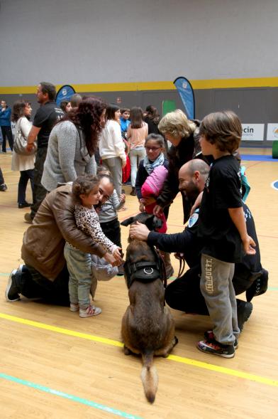 Iª Exhibición de la Unidad Canina de la Policía Local - Imagen de un policía y su perro policía junto a unos niños.