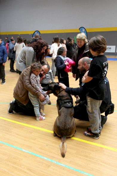 Iª Exhibición de la Unidad Canina de la Policía Local - Imagen de un policía y su perro policía junto a unos niños.