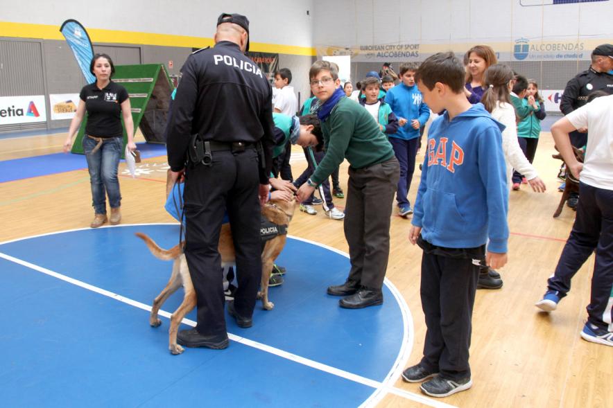 Iª Exhibición de la Unidad Canina de la Policía Local - Imagen de un policía y su perro policía junto a unos niños.
