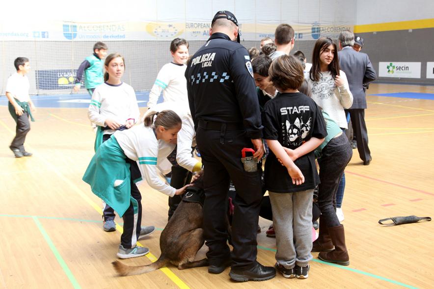 Iª Exhibición de la Unidad Canina de la Policía Local - Imagen de un policía y su perro policía junto a unos niños.