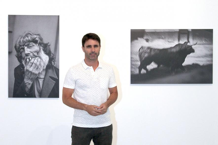 Fotógrafo Aitor Lara, posando con dos de sus fotos. 