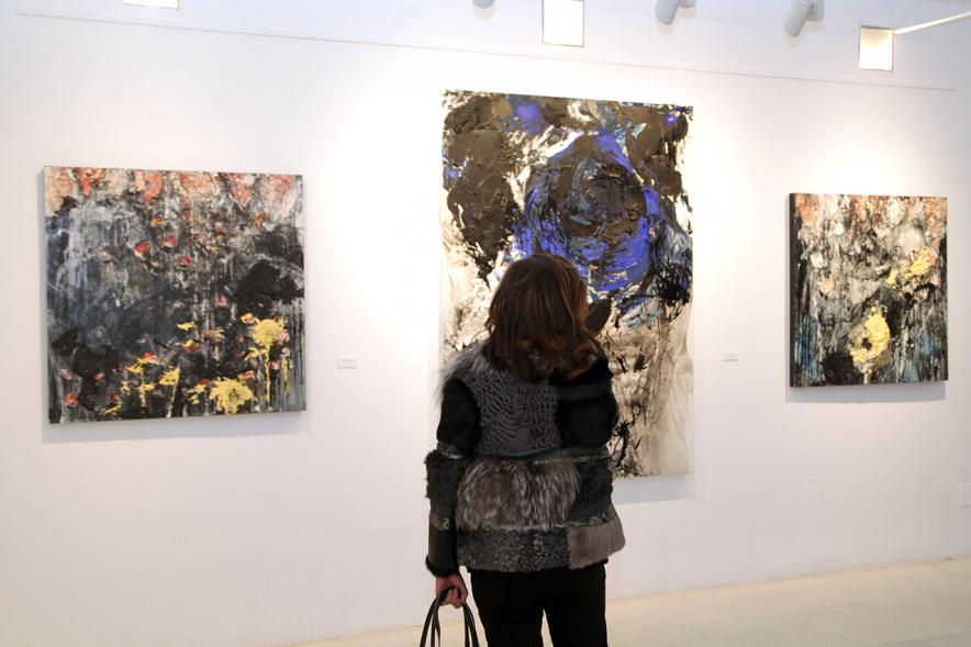 Inauguración de la Exposición de Manuel Martín Cabrera - Imagen de una persona admirando uno de los cuadros expuestos en la exposición.