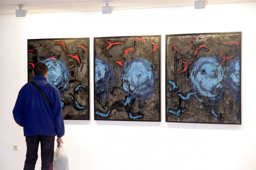Inauguración de la Exposición de Manuel Martín Cabrera - Imagen de una persona admirando uno de los cuadros expuestos en la exposición.