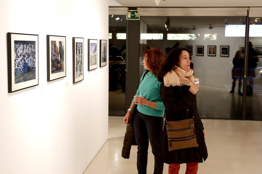 Exposición VIIº Concurso de Fotografía Ciudad de Alcobendas - Imagen de personas asistentes a la exposición mirando las obras expuestas.