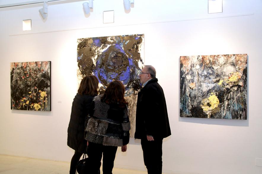 Inauguración de la Exposición de Manuel Martín Cabrera - Imagen de unas personas admirando  los cuadros expuestos en la exposición.
