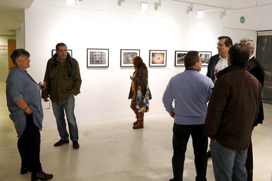 Exposición VIIº Concurso de Fotografía Ciudad de Alcobendas - Imagen de personas asistentes a la exposición mirando las obras expuestas.