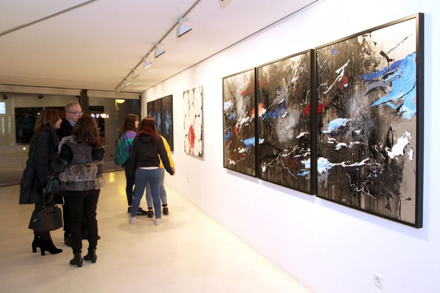 Inauguración de la Exposición de Manuel Martín Cabrera - Imagen de unas personas admirando los cuadros expuestos en la exposición.