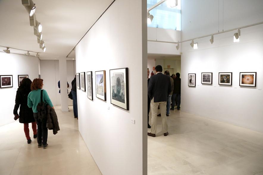 Exposición VIIº Concurso de Fotografía Ciudad de Alcobendas - Imagen de personas asistentes a la exposición mirando las obras expuestas.