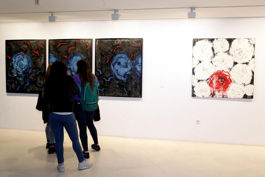 Inauguración de la Exposición de Manuel Martín Cabrera - Imagen de unas personas admirando uno de los cuadros expuestos en la exposición.