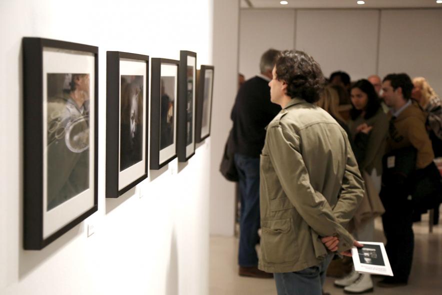 Exposición VIIº Concurso de Fotografía Ciudad de Alcobendas - Imagen de personas asistentes a la exposición mirando las obras expuestas.
